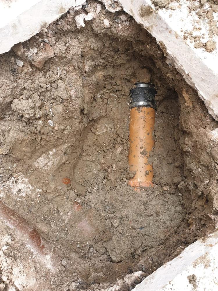 New drain pipe and coupling fitted in a repair excavation